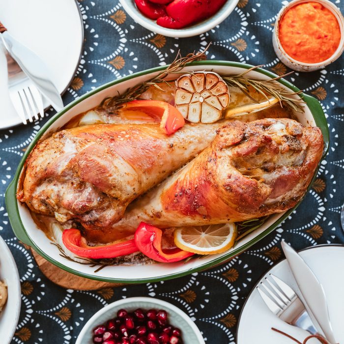 Festive dish for Thanksgiving, roasted turkey legs with vegetables on a table with snacks. Top view, flat lay.