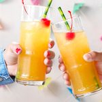 Nutty Hawaiian; straight on camera angle; white background; shiplap; beverage; beverages; tropical; hawaiian; island; festive; party; refreshing; Southern Comfort; coconut rum; amaretto; pineapple juice; Maraschino cherries; hands; copy space; opener