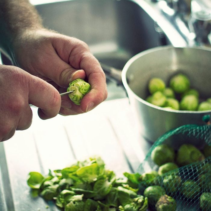 Brussels Sprouts being prepared at a kitchen sink in readiness for Christmas Dinner
