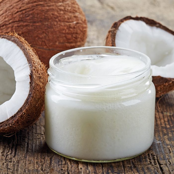 healthy oils coconut oil and fresh coconuts on old wooden table