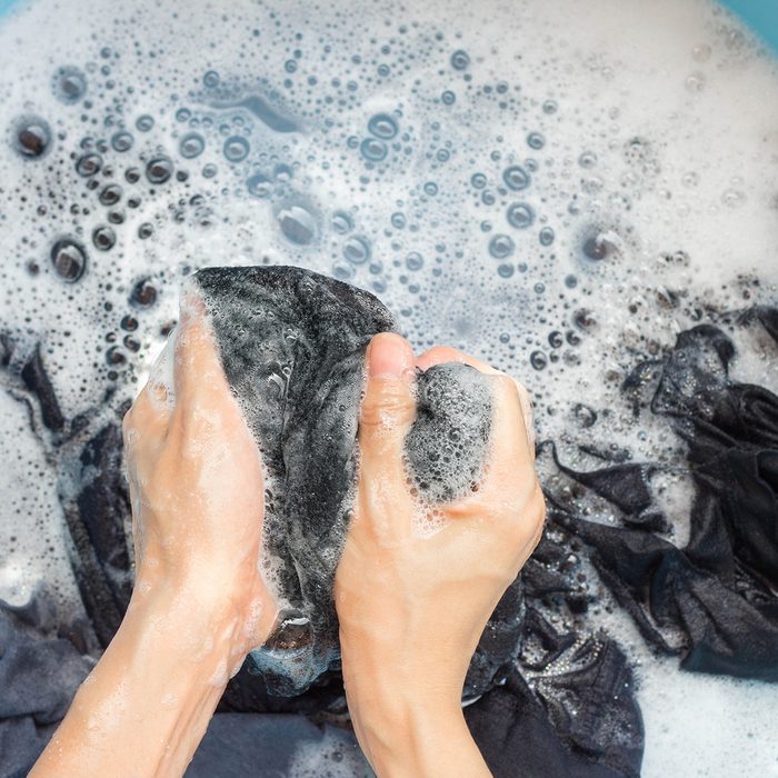 Cropped Hands Of Person Washing Laundry In Bucket