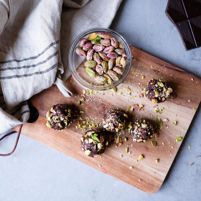 High Angle View Of Chocolate Pistachio Truffle On Cutting Board At Kitchen Counter