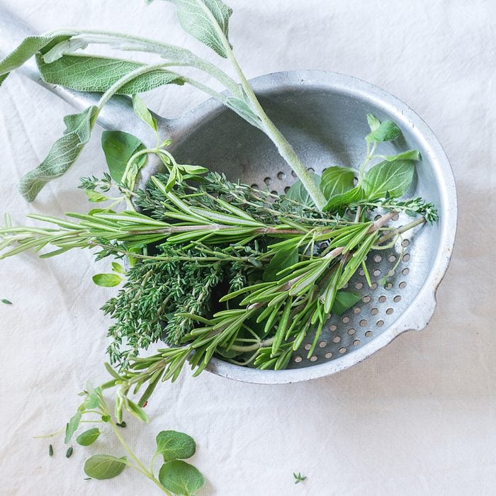 colander uses High Angle View Of Green Herbs In Colander On White Table