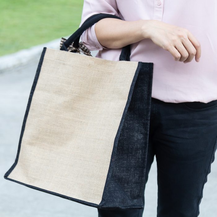 Working woman carry simple flax eco bag with copy space, plastic free concept.