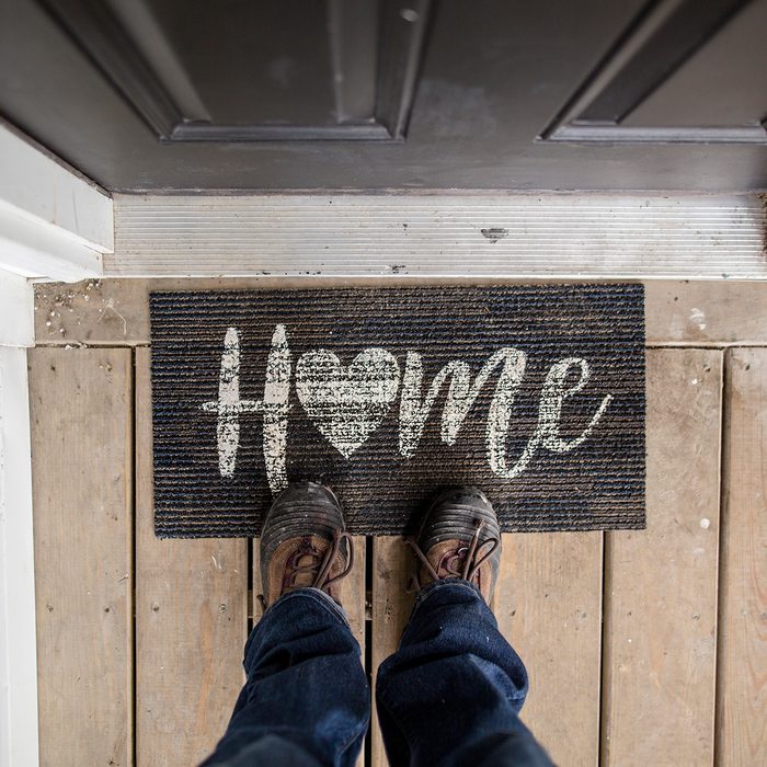 Close Up Of Person Standing On Doormat At The Entry Of A Home