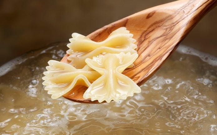 what is al dente Cooked Farfalle On Wooden Spoon Above A Pot