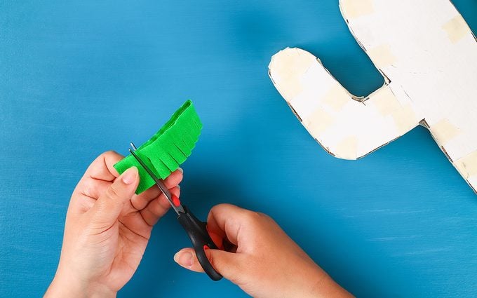 how to make a pinata Diy cinco de mayo Mexican Pinata Cactus made cardboard and crepe paper your own hands on a blue background. Gift idea, decor, game cinco de mayo. Step by step. Top view. Process kid children craft.