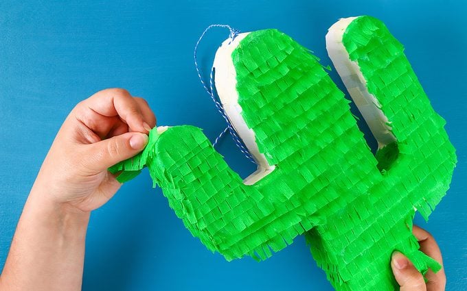 how to make a pinata Diy cinco de mayo Mexican Pinata Cactus made cardboard and crepe paper your own hands on a blue background. Gift idea, decor, game cinco de mayo. Step by step. Top view. Process kid children craft.