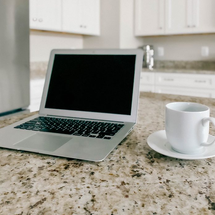 Laptop And Coffee Cup On Kitchen Island