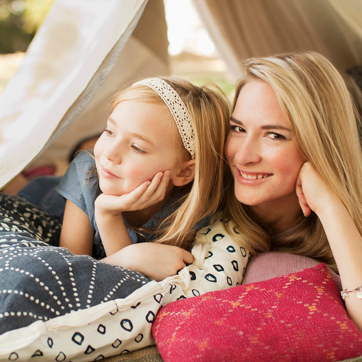 Mother And Daughter Laying In Tent Outdoors