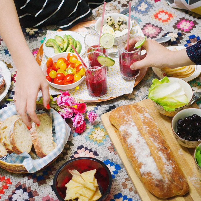 Two Women Having Picnic On Rug