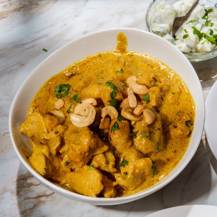 traditional jamaican foods Indian korma curry dinner with raita on marble kitchen table