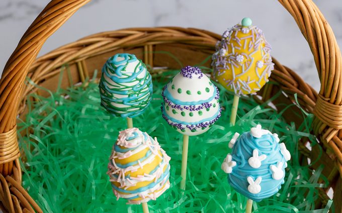 easter cake pops Cake pops in a basket with Easter grass.
