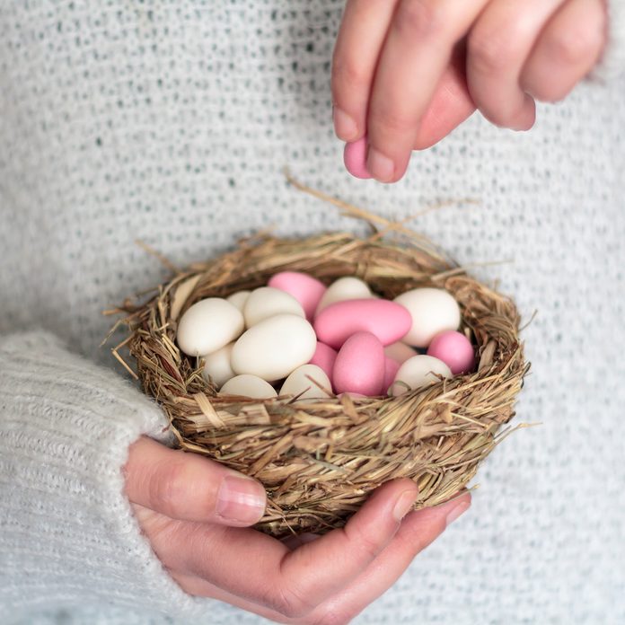 easter traditions around the world Woman Hands Holding Bird Nest With Sugared Easter Eggs
