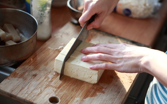 what is tofu cutting Tofu on the chopping board in Kitchen