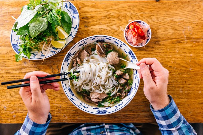 Man Eating Vietnamese Pho Soup With Noodles And Beef, Personal Perspective View