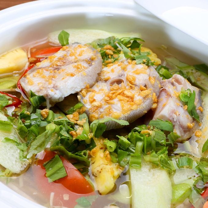 vietnamese recipes Sour Soup In Vietnamese Style With Grouper Fish In White Bowl