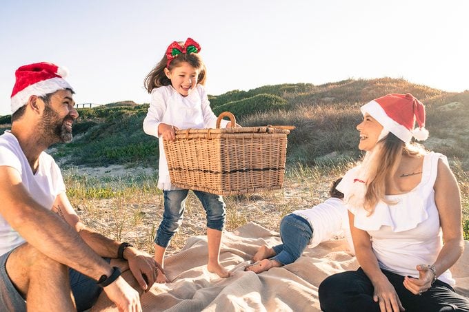 Little Girl Picks Up Heavy Basket Full Of Present Family Summer Christmas On The Beach
