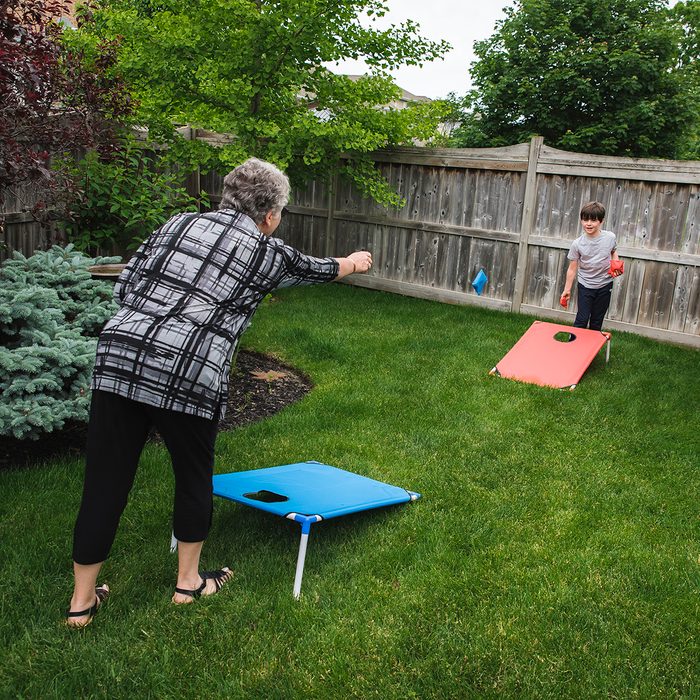 backyard entertainment ideas Grandmother And Grandson Playing Corn Hole Game In A Backyard.