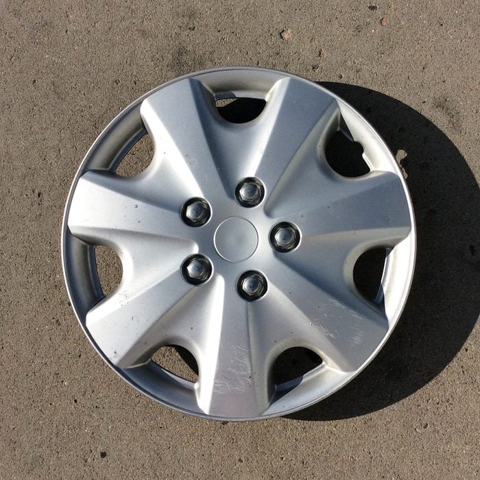 High Angle View Of Hubcap On Footpath