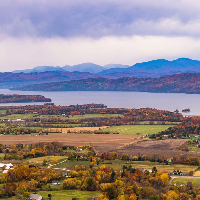 view of rural Vermont farm valley in autumn with Lake Champlain and the Adirondack Mountains in distance
