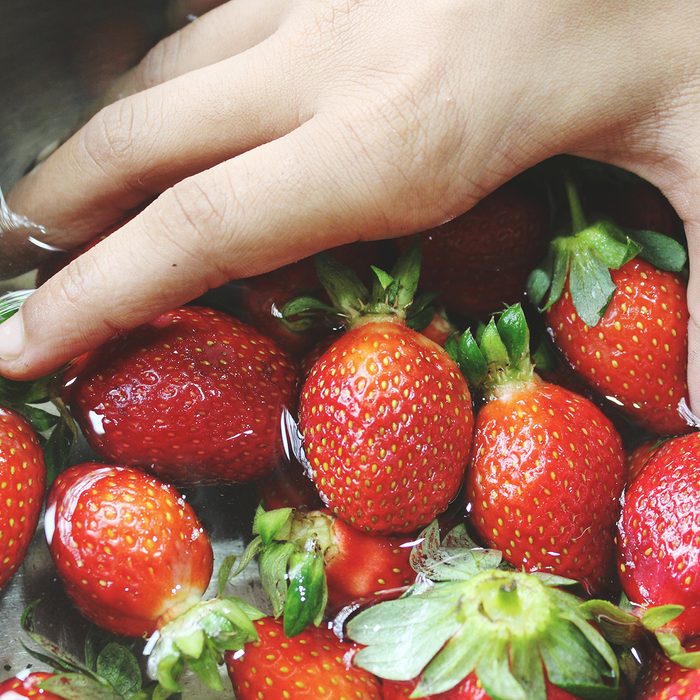 how to wash berries Close Up Of Hand Washing Strawberries