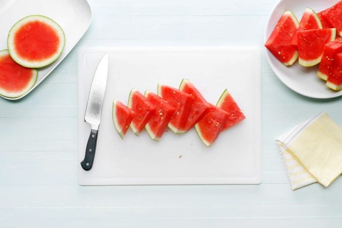 triangular slices of watermelon on a white cutting board