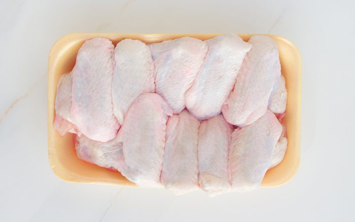 how to defrost chicken Chilled Chicken Wings In A Yellow Tray, Fresh Meat From The Store On A White Table. High Protein In Chicken