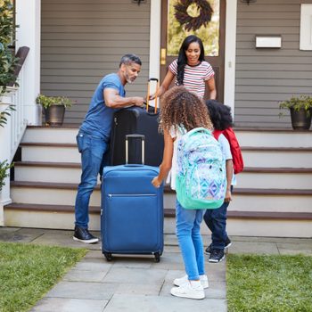 Family With Luggage Leaving House For Vacation