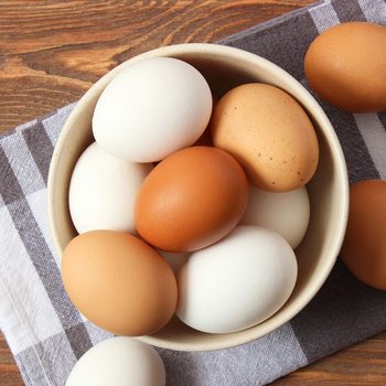 Brown and White Eggs in a bowl over a rag cloth