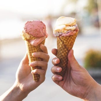 close up of two people holding ice cream cones