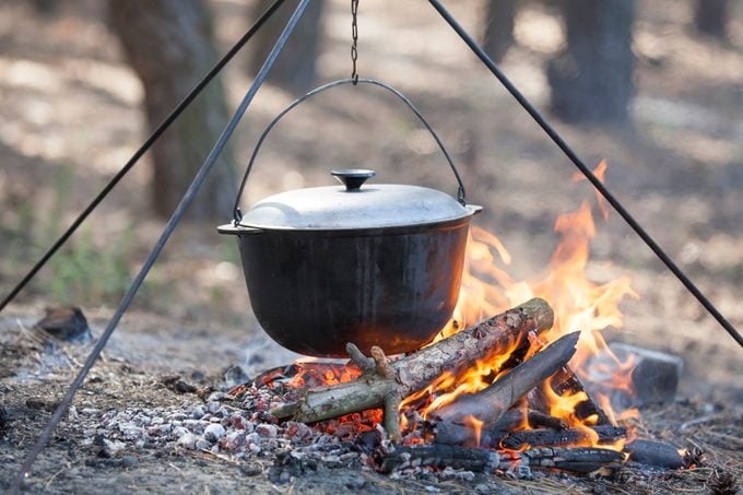 dutch oven over a campfire in the woods