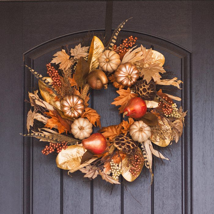 fall wreath made with faux gourds, pinecones and leaves