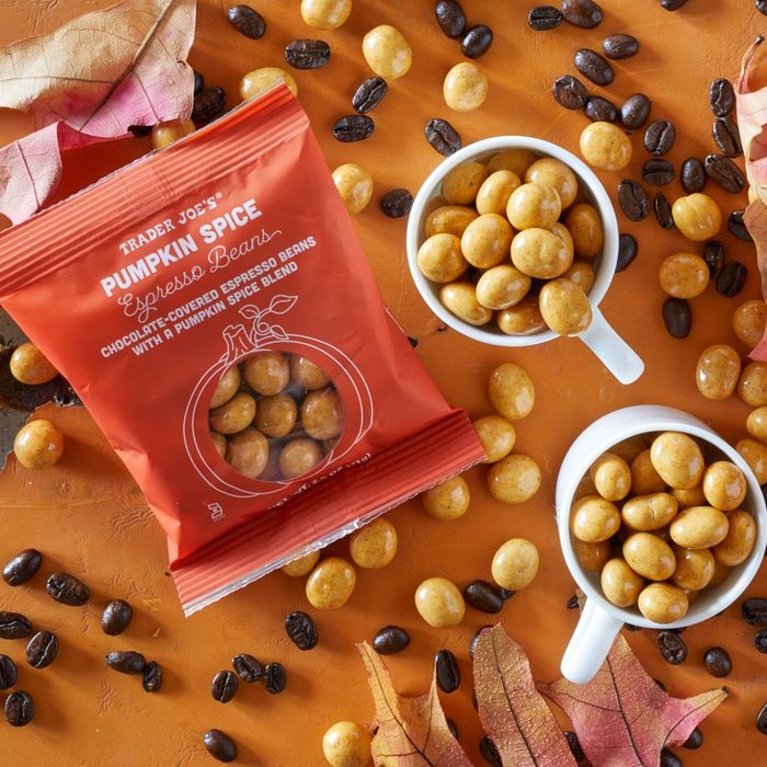Trader Joe's Pumpkin Espresso Beans piled in two espresso cups, and scattered on surface with coffee beans and fall leaves