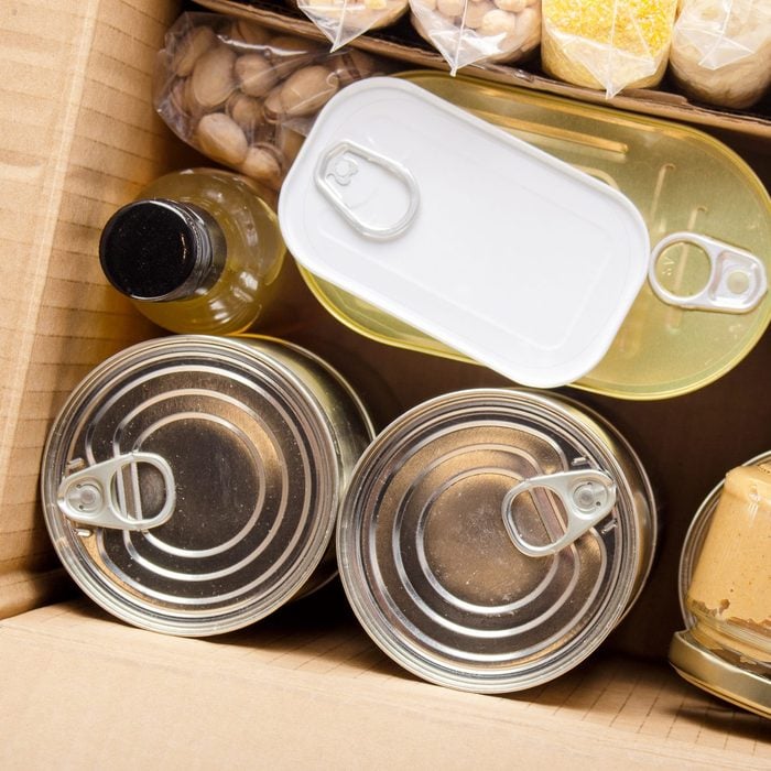 Flat lay view at groceries in carton box prepared for disaster emergency conditions or giving away