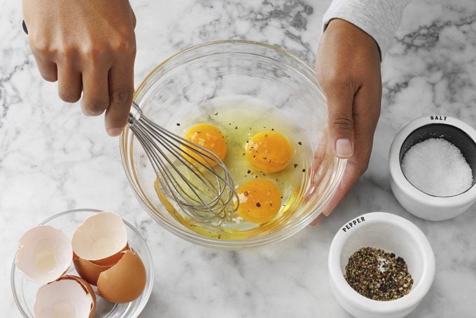 whisking eggs in bowl for scrambled eggs