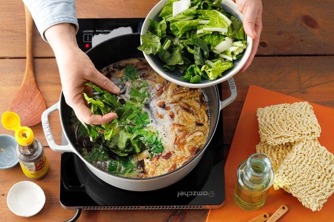 Pork Ramen with mushrooms garlic ginger mirin soy sauce simmering while adding bok choy