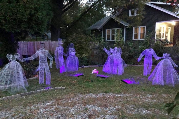 Chicken Wire Ghost Group Outdoor Halloween Decor in the yard of a house at twilight