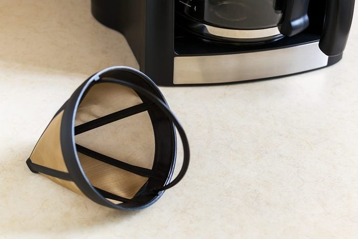 Reusable metal mesh coffee filter for drip coffee maker. Permanent basket coffee filter on white background.