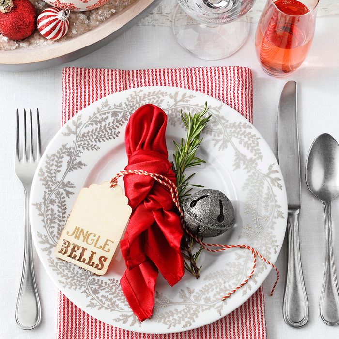 Place setting with a christmas jingle bells theme on a white table
