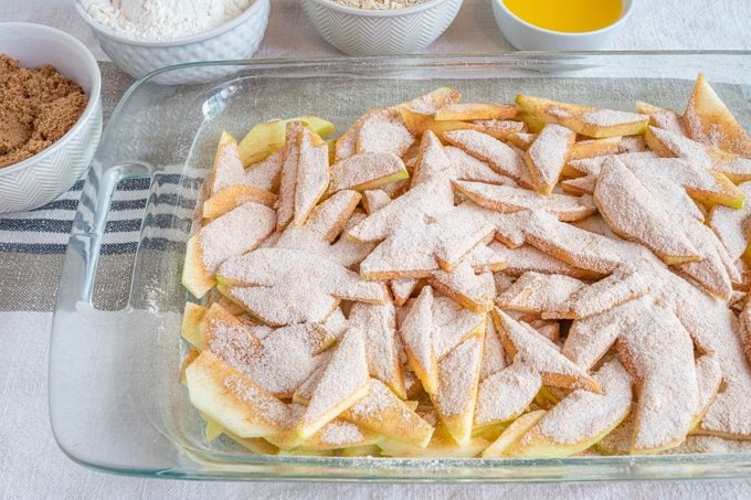 glass pan of sliced apples for pioneer woman apple crisp recipe