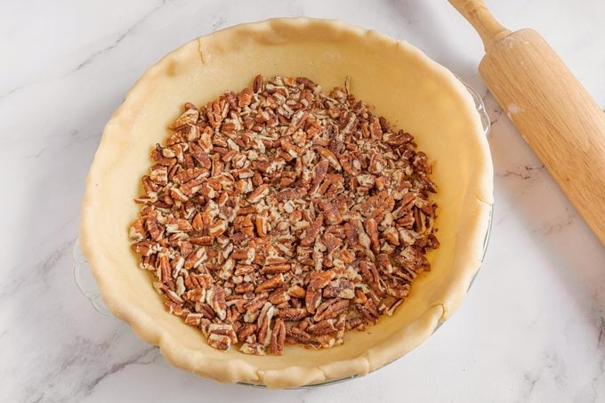 Filling The Pie Crust For Pecan Pie