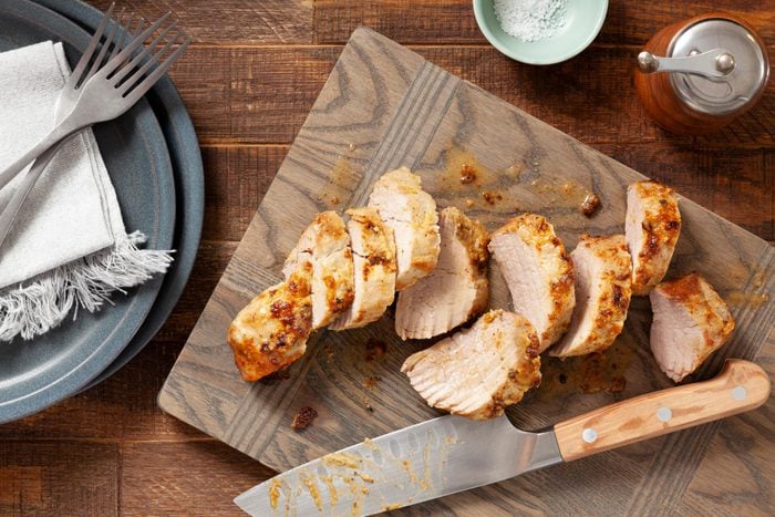 A Sliced Air Fryer Pork Tenderloin on a Cutting Board