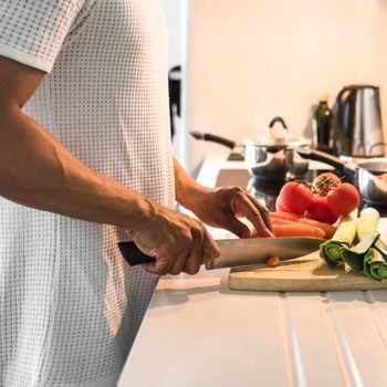 man cutting vegetables in kitchen