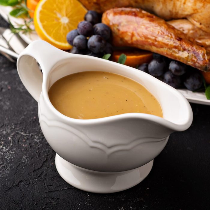 Homemade gravy in a sauce dish with turkey in background
