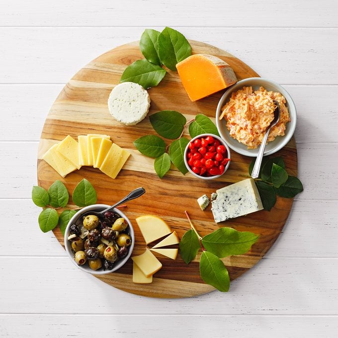 adding greenery and bowls to charcuterie board