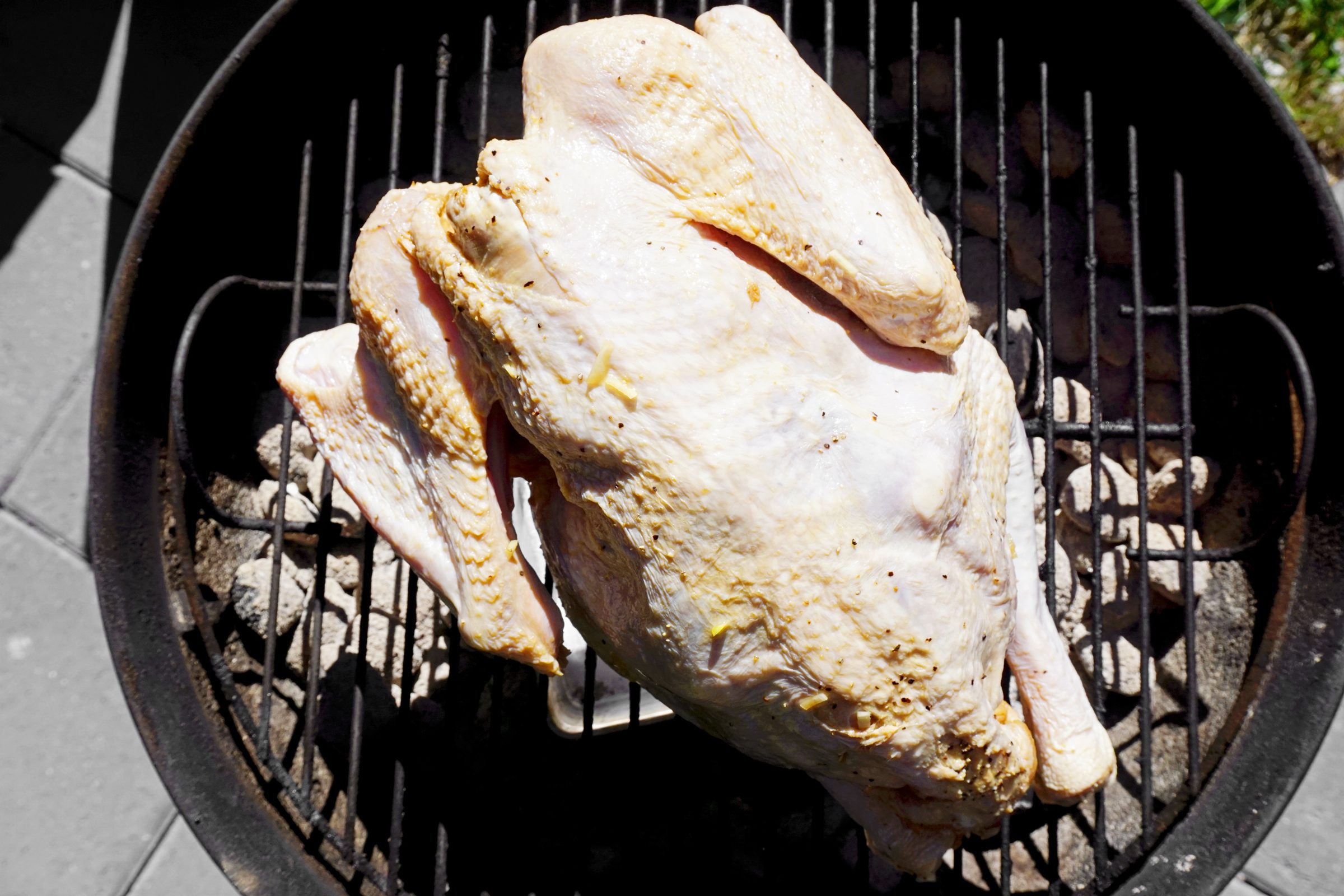 a raw turkey sitting on the grill
