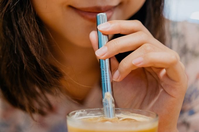 Young Asian Woman Drink Coffee Using Metal Straw