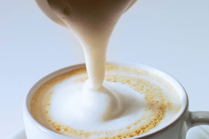 Pouring frothed milk on Cappuccino
