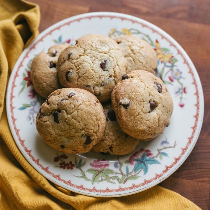 Ghirardelli Chocolate Chip Cookies on a white floral plate on a wood kitchen countertop